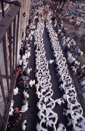 fila di devoti con sacco bianco